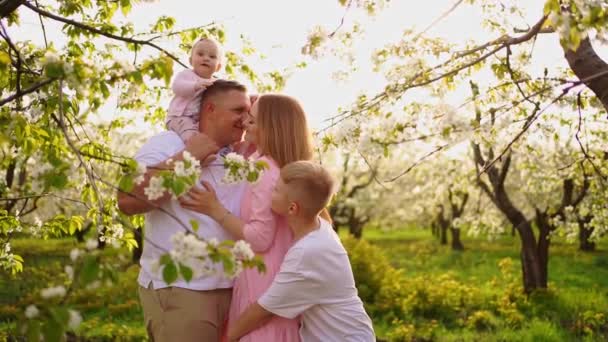 Сім'я з сином і дочкою у весняному квітковому саду. розщеплення губ у немовлят . — стокове відео