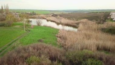 Köydeki bir göletin üzerinde, tarlaların arasında uçuyordu. bahar manzarası.