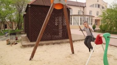 Salıncakta sallanan çocuk. Çocuk parkında eğlence.