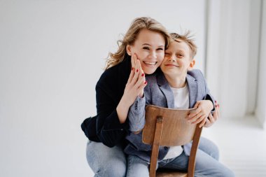 Mavi elbiseli bir anne eğleniyor ve fotoğraf çekimi için poz veriyor.