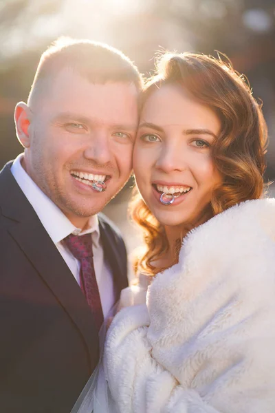 Bruden och brudgummen håller vigselringar i tänderna. — Stockfoto