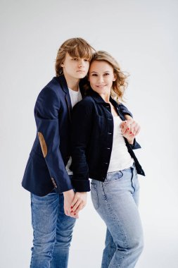 Mavi elbiseli bir anne fotoğraf çekimi için poz verir.