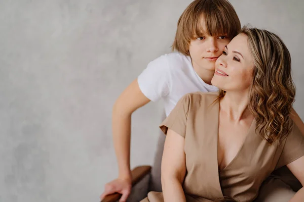 Mutter und Sohn posieren in beige-weißer Kleidung für ein Fotoshooting — Stockfoto