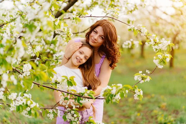 Мать и дочь в цветущем весеннем саду. натуральная косметика — стоковое фото