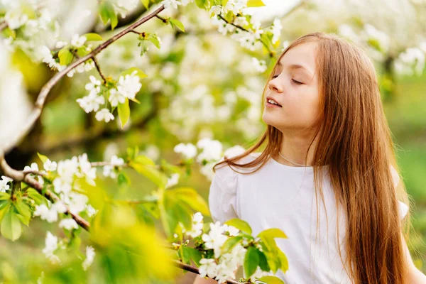 Vacker tonårstjej med en gren av ett blommande träd. naturliga kosmetika — Stockfoto