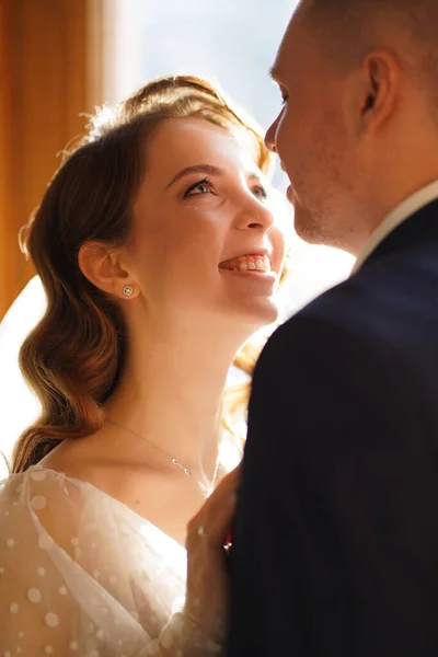 Silhouetten von Braut und Bräutigam im Sonnenlicht durch das Glas in der Tür. — Stockfoto