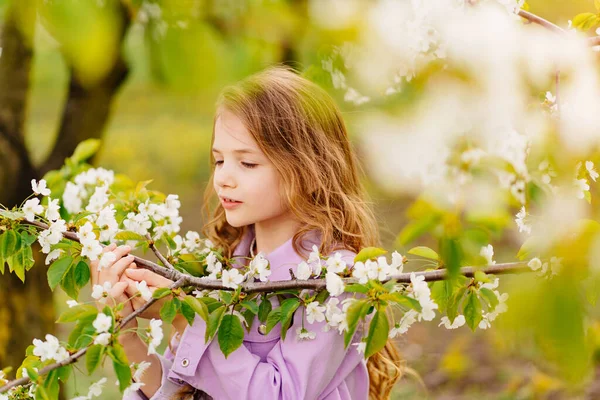 Beautiful kid girl with a branch of a flowering tree. natural cosmetics — Stock Photo, Image