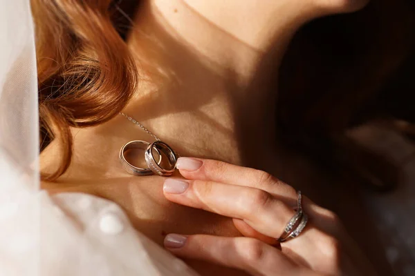 Wedding rings on the brides collarbone. traditional wedding decorations — Stock Photo, Image