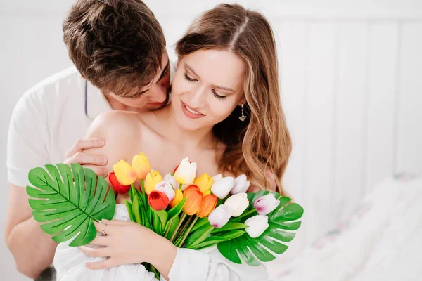 Un homme a donné à sa bien-aimée femme un bouquet de tulipes colorées. doux baiser — Photo