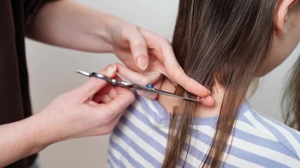 Стрижка. мама відрізає дочки волосся ножицями . — стокове відео