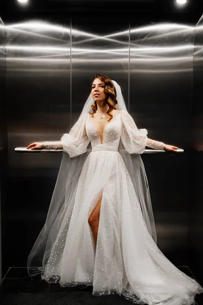 하얀우아 한 드레스를 입은 신부, 긴 베일 이 어두운 리프트 안 에서 있는 모습. — 스톡 사진