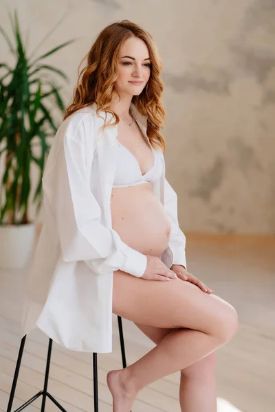 Mooie zwangere vrouw in wit shirt. de schoonheid van het vrouwelijk lichaam. — Stockfoto