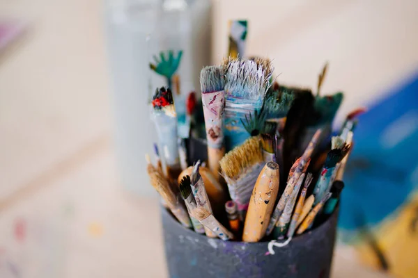 A cup with dirty brushes after drawing. accessories and tools for the artist. — стоковое фото