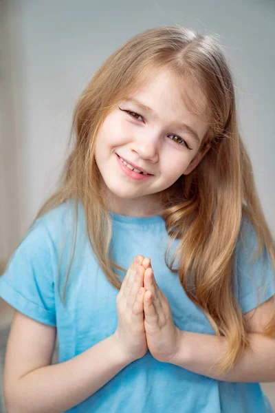 Une petite fille aux longs cheveux blonds se maquillait, tirait des flèches sur les paupières. — Photo