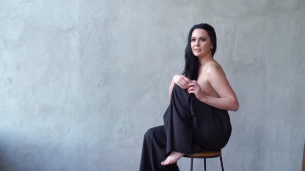 Una hermosa mujer en topless sentada en una silla alta. — Vídeos de Stock
