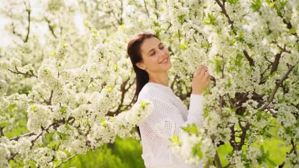 Bela jovem mulher junto à árvore florida. cosméticos e perfumes naturais. — Vídeo de Stock