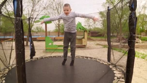 Il ragazzo salta sul trampolino. animazione per bambini all'aperto. — Video Stock