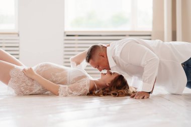 Beyazlı çift yerde yatan bir çocuğun doğmasını bekliyor. ortak doğumlar