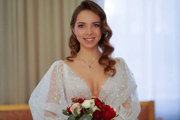 beautiful bride with long curls, in an elegant dress with a bouquet