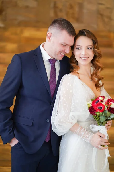 A beautiful couple of newlyweds with a bouquet. — Stock Photo, Image