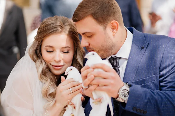 Braut und Bräutigam halten ein Paar weiße Tauben. — Stockfoto