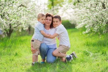 Oğulları olan bir anne çiçek bahçesinde sarılır. Anneler Günü