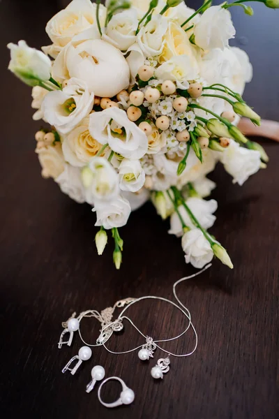 Bruiloft boeket en sieraden voor de bruid op het nachtkastje. — Stockfoto