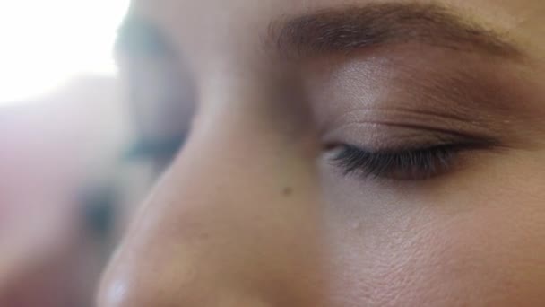 Nahaufnahme. Ein schönes Mädchen mit langen Haaren machen Augen Make-up. — Stockvideo