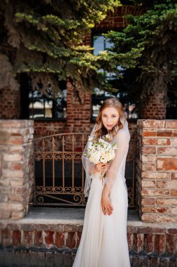 Tam boy. Bir buket çiçekli mutlu ve güzel gelin.