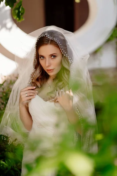 Novia con el pelo ondulado largo en el jardín. Maquillaje de boda. — Foto de Stock