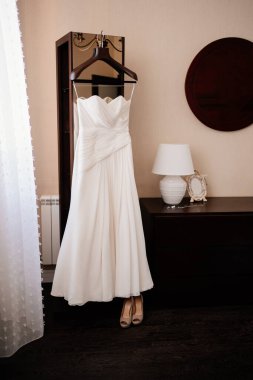 Askıda zarif, beyaz bir gelinlik. Düğün gününün sabahı,