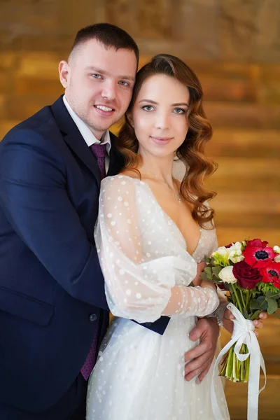 Ein schönes Brautpaar mit einem Strauß. — Stockfoto