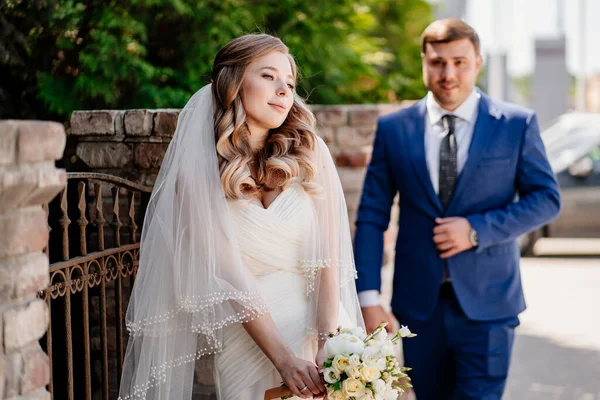 Los novios junto a la valla retro. boda al aire libre —  Fotos de Stock