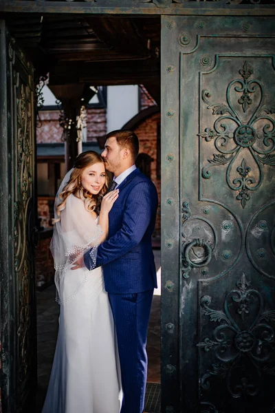 Наречена і наречений калюжа стоять у ретро ворота — стокове фото