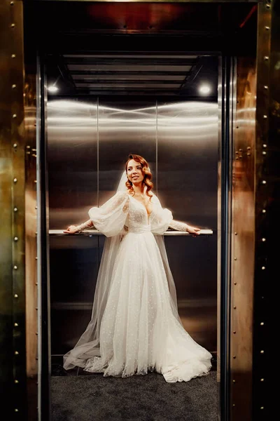 하얀우아 한 드레스를 입은 신부, 긴 베일 이 어두운 리프트 안 에서 있는 모습. — 스톡 사진