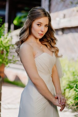 Bahçede uzun dalgalı saçlı gelin. Düğün makyajı.. 