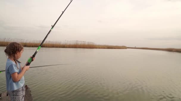 Pescador. Niña en una caña de pescar del río. vacaciones en la naturaleza. — Vídeos de Stock