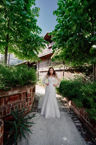Novia en el sendero en el jardín. Maquillaje de boda. — Foto de Stock