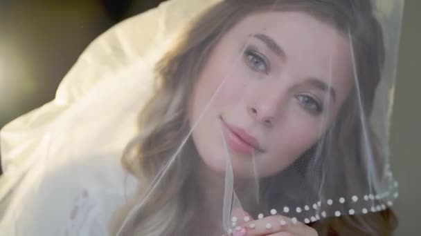 Nevěsty ráno. krásná mladá žena s dlouhými vlasy pod závojem — Stock video