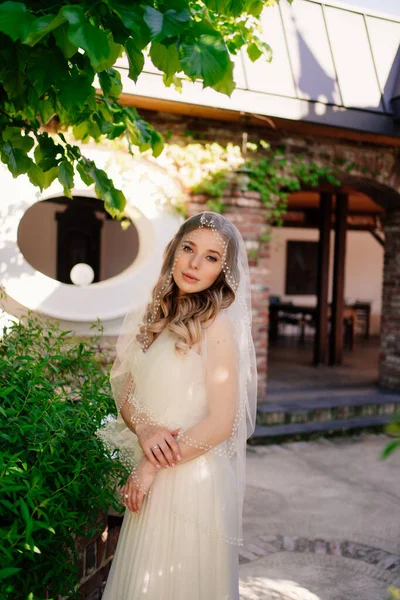 庭に長い波状の髪の花嫁。結婚式の化粧. — ストック写真