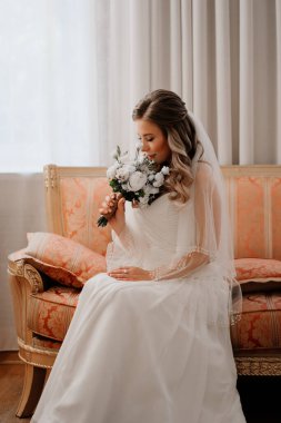 Kanepede buketi olan güzel bir gelinin portresi. Düğün gelenekleri..