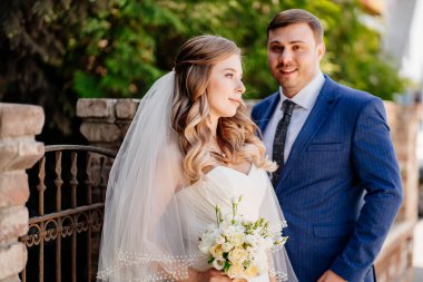 Gelin ve damat eski çitlerin yanında duruyor. 