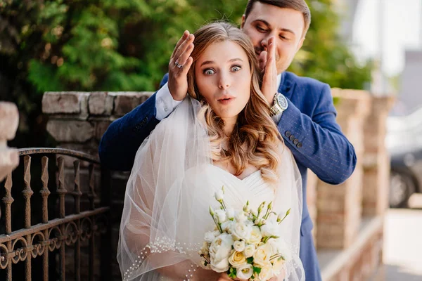 Primera reunión de los recién casados. Los novios felices junto a la valla retro —  Fotos de Stock