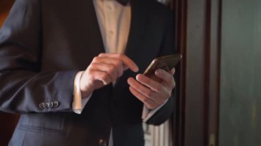 Takım elbiseli bir adam akıllı telefonuyla mesaj yazar.. 