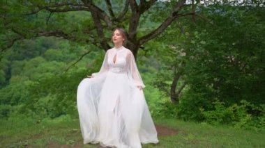 Ormanda, dağlarda gelinlik içinde mutlu genç bir kadın.