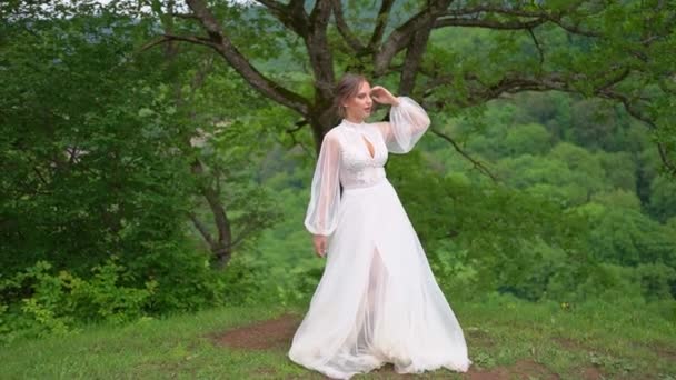 Bela jovem mulher em um vestido de noiva na floresta nas montanhas — Vídeo de Stock