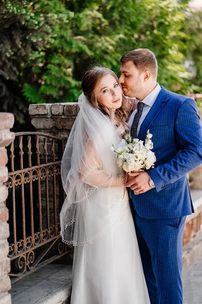 Gelin ve damat eski çitlerin yanında duruyor. — Stok fotoğraf