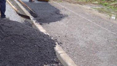 Kürekli işçiler yola asfalt koydular..