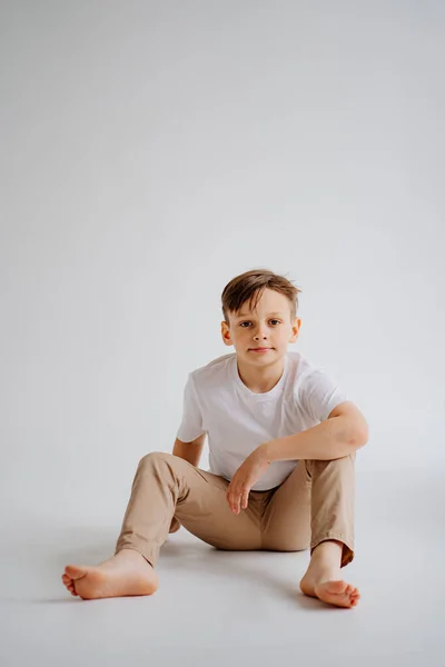 Tonårspojken i vit T-shirt poserar i en fotostudio. problem för tonåriga pojkar. — Stockfoto