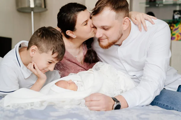 Yeni doğan bebeğin evde ilk günü. Yatak odasında yeni yürümeye başlayan mutlu bir aile. — Stok fotoğraf